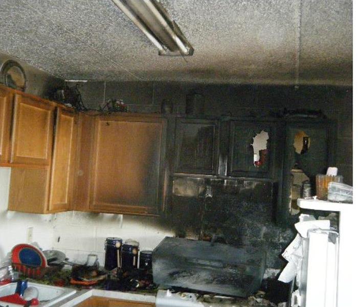 kitchen fire with damage to stove and cabinets